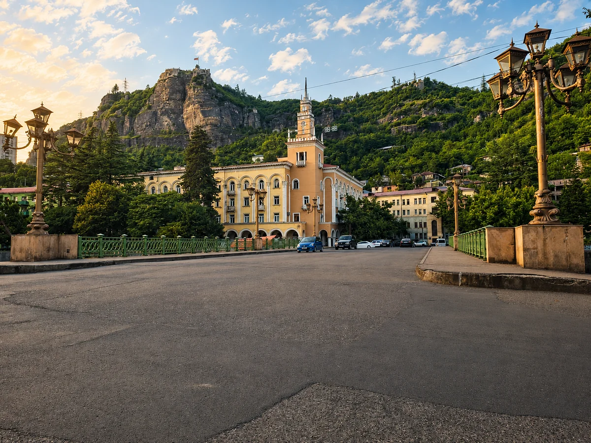A street and square in Chiatura below wooded cliffs at sunset, Imereti, Georgia