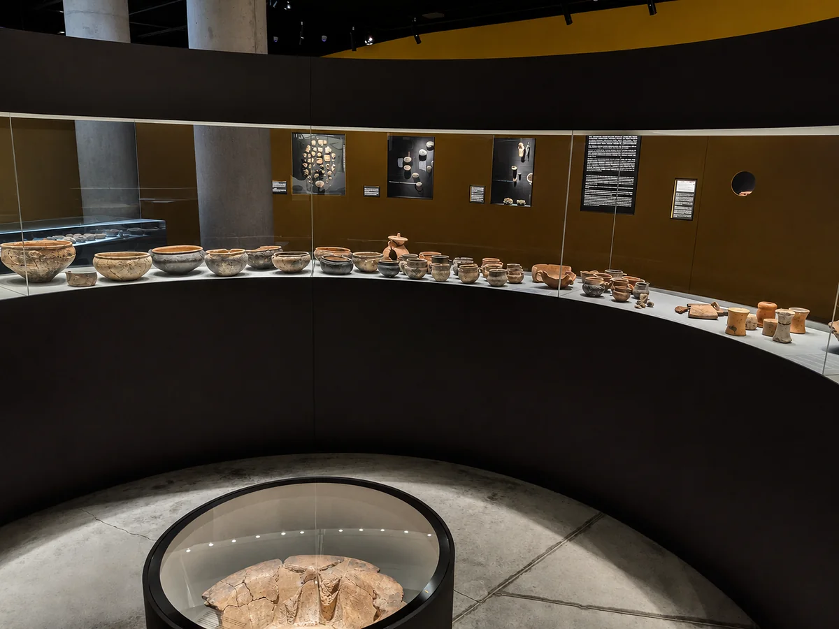Curved gallery of the Bolnisi Museum with a long sweeping case of prehistoric pottery, Georgia
