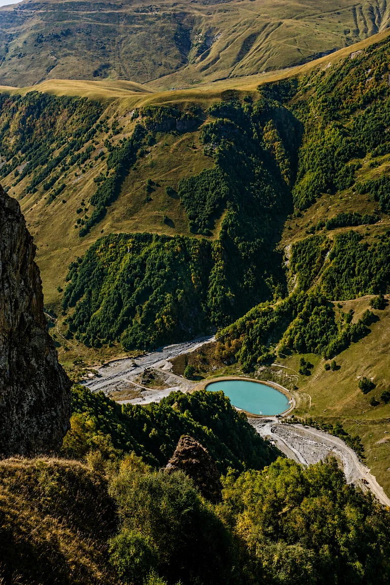 Pohled dolů do Ďáblova údolí z vyhlídky Gudauri Panorama, zalesněné svahy klesající k řece a Gruzínské vojenské cestě, Gruzie