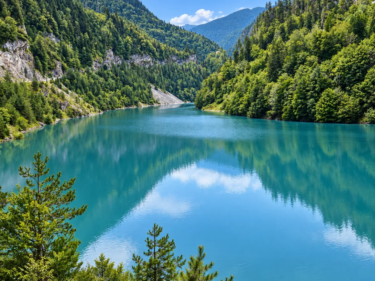 La route Zugdidi–Mestia taillée dans la falaise au-dessus du réservoir turquoise de l'Enguri, Géorgie