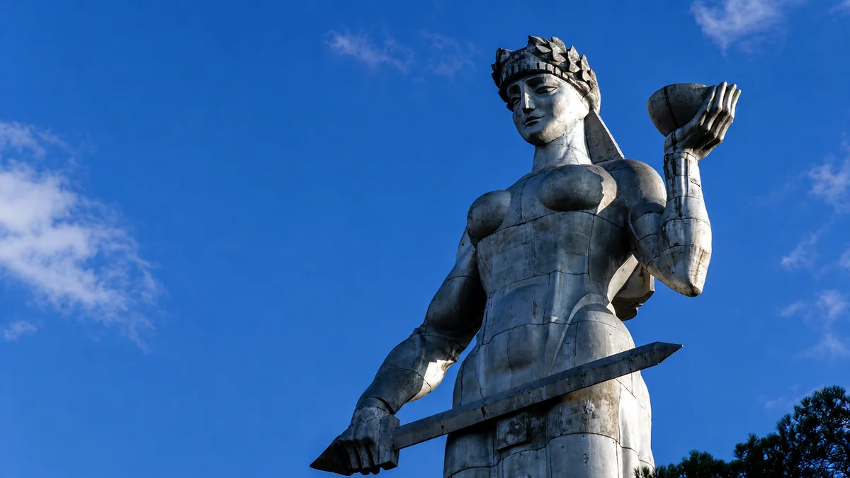 Gros plan de la statue Kartlis Deda sur ciel bleu, tenant une coupe de vin dans la main gauche et une épée dans la droite, Tbilissi, Géorgie