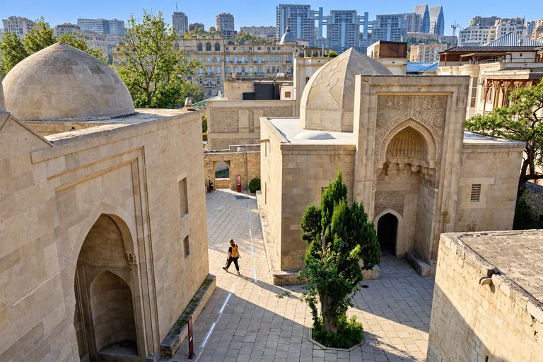 Palác širvánšáhů v hrazeném Starém Městě Baku zapsaném na seznamu UNESCO, středověký pískovcový palácový komplex s kupolemi nad moderní panoramatem města, Ázerbájdžán