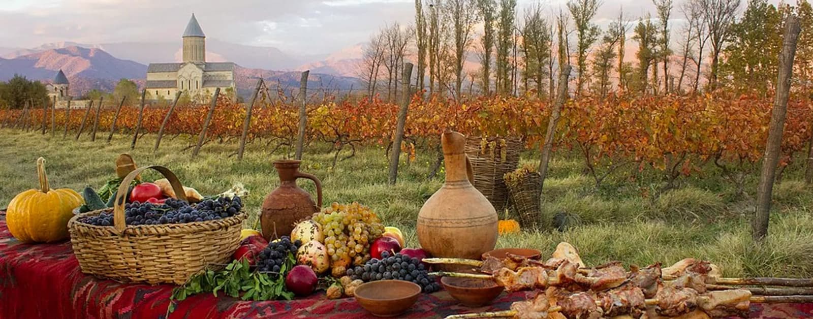Georgian wine-harvest feast with clay qvevri jugs, grapes and grilled mtsvadi in a Kakheti vineyard