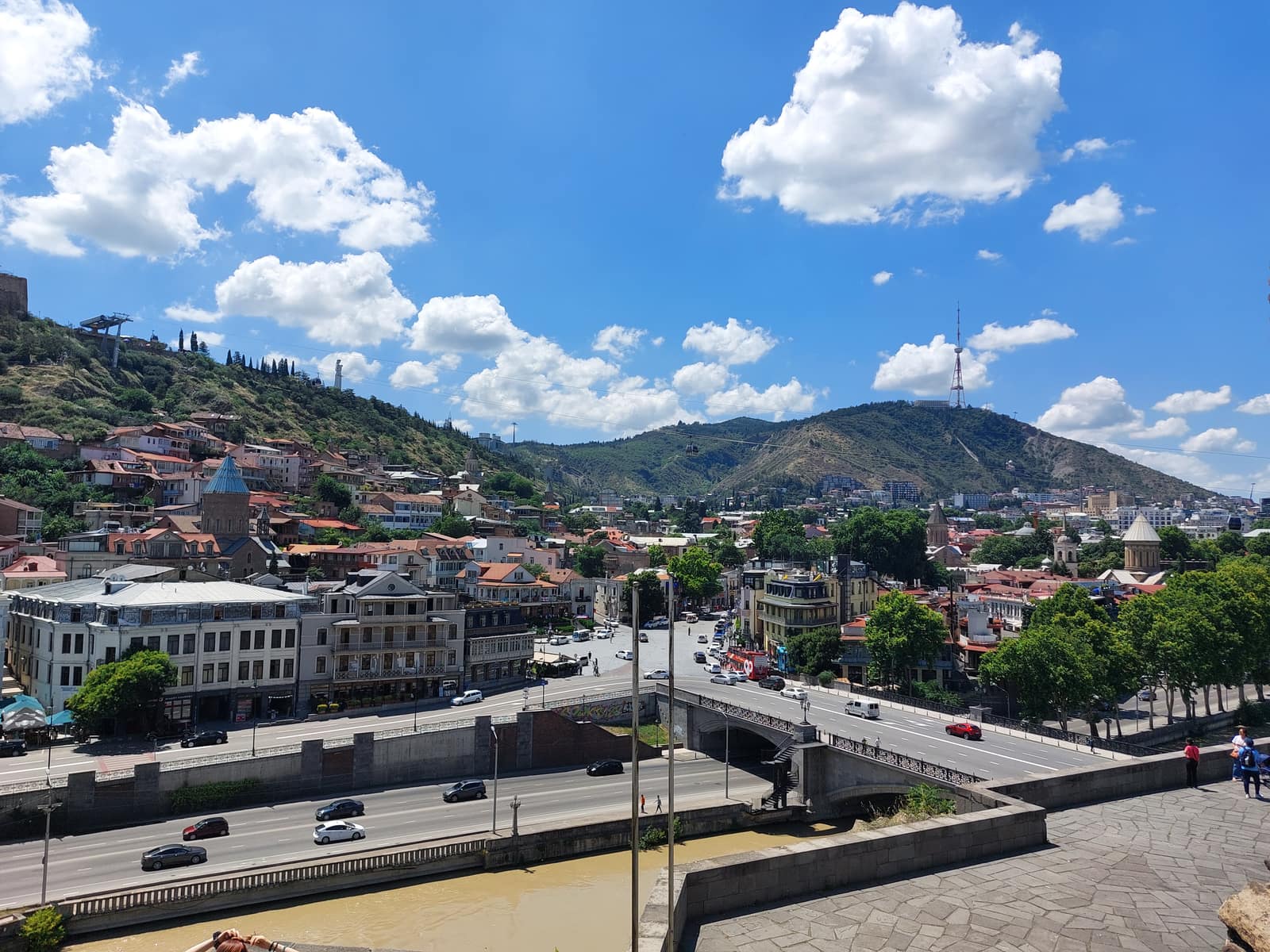 Vue sur la rivière Mtkvari jusqu'au pont Metekhi avec le mont Mtatsminda qui s'élève derrière Tbilissi