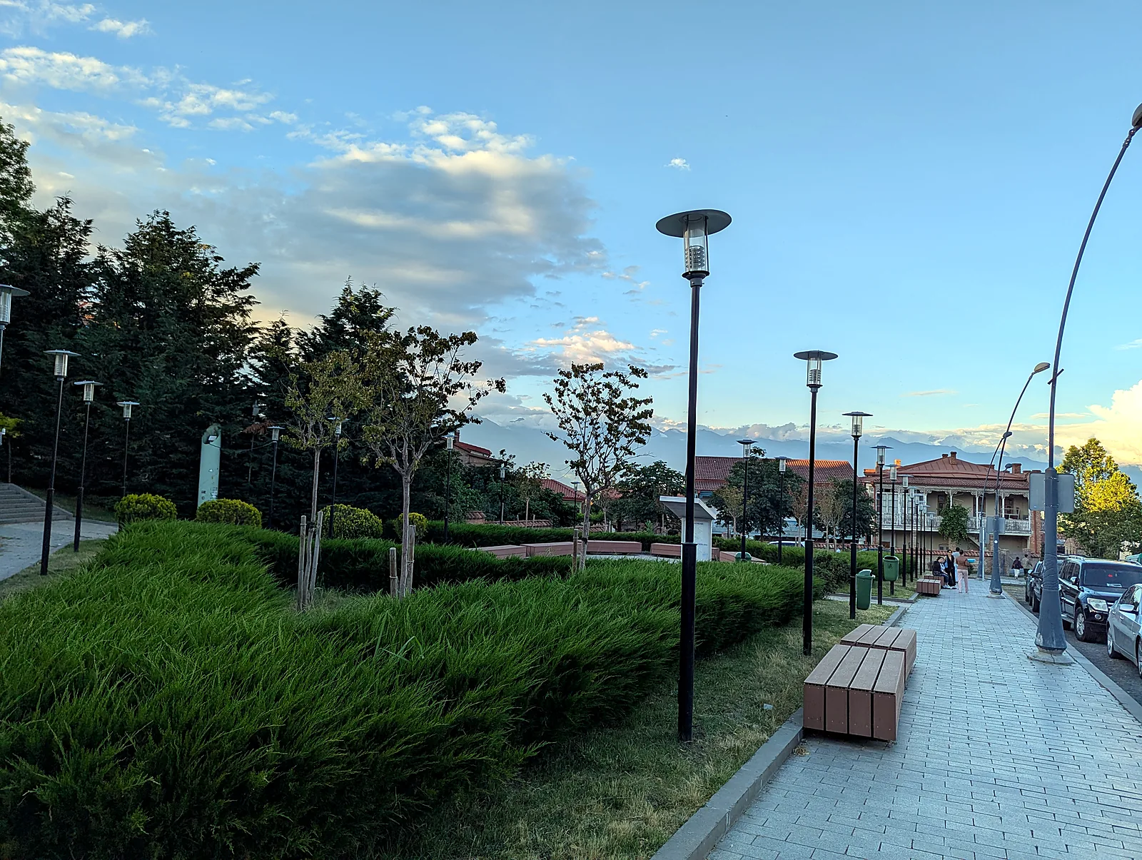Angelegter Park und Promenade im Zentrum von Telawi, Kachetien, Georgien, mit dem Großen Kaukasus in der Abenddämmerung