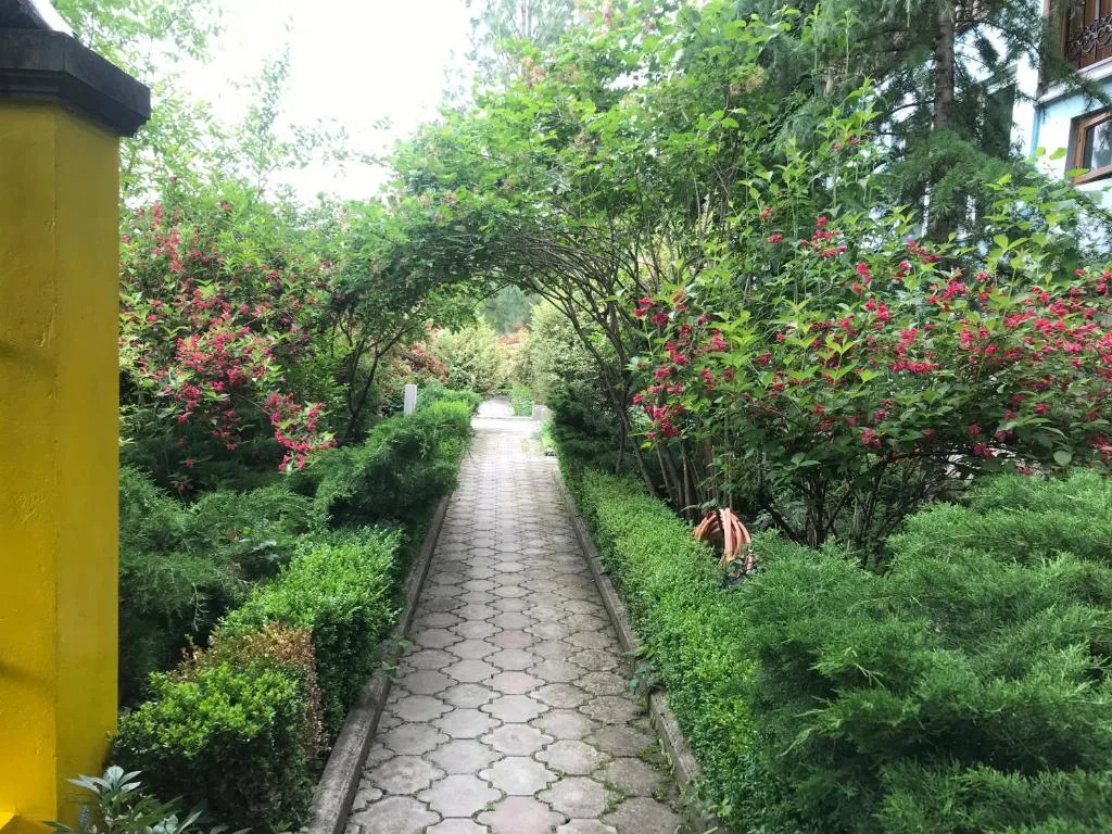 Tuinpad tussen bloeiende struiken, Casanova Inn in Dilijan, Armenië