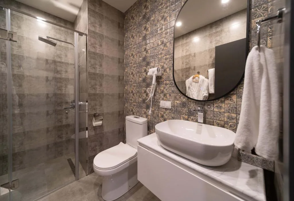 Badkamer met inloopdouche en ronde spiegel, Dili Town Resort and Spa in Dilijan, Armenië
