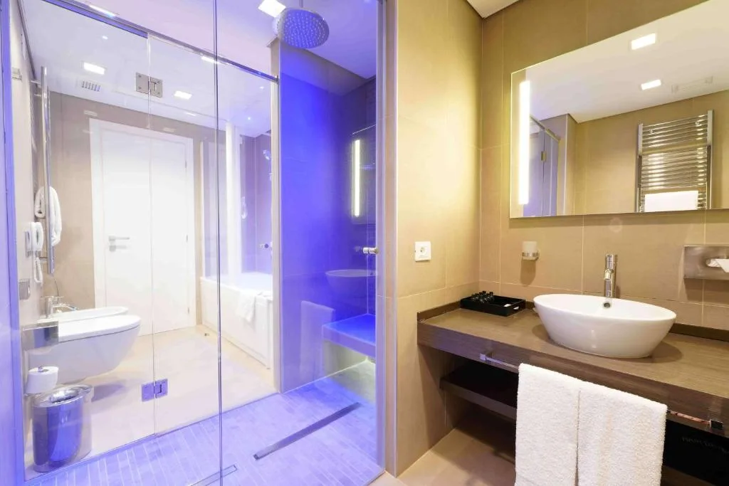 Salle de bains du DoubleTree by Hilton Yerevan City Centre avec douche à l'italienne et vasque