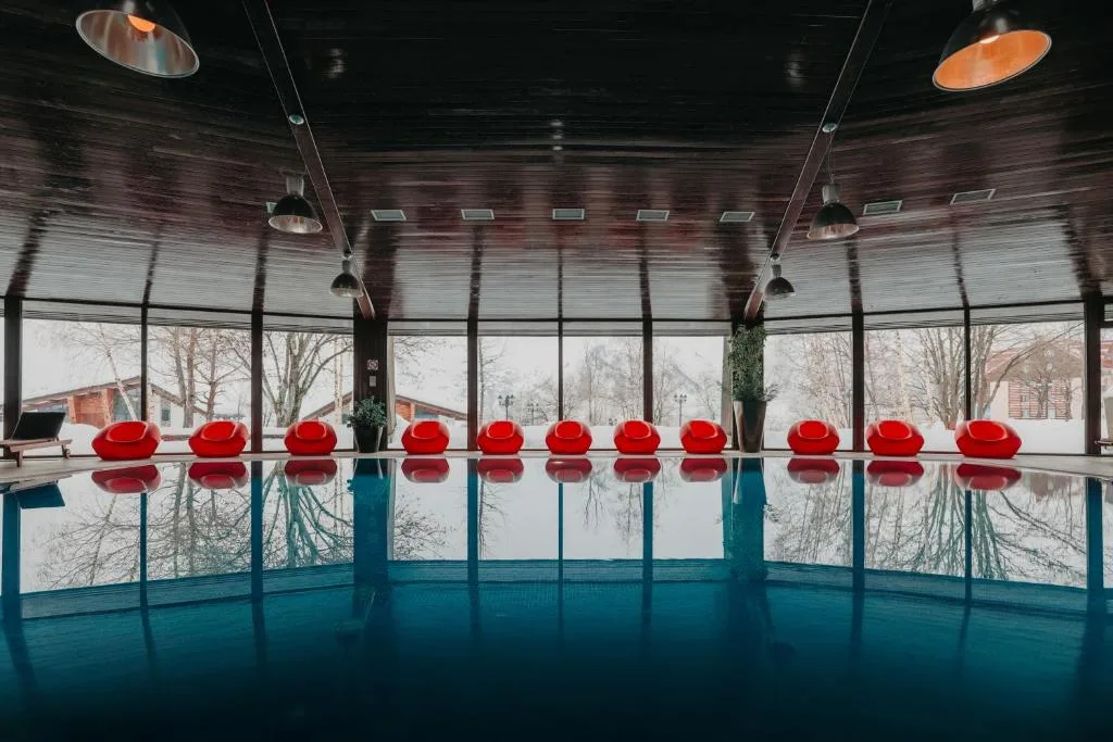 Hallenbad mit großen Fenstern zum verschneiten Gelände im Marco Polo Hotel Gudauri, Georgien