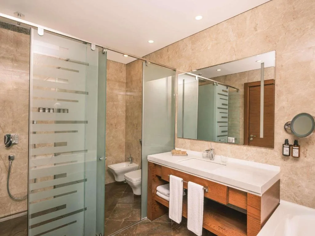 Łazienka ze szklaną kabiną prysznicową i umywalką, Mövenpick Winter Park Baku w Baku, Azerbejdżan