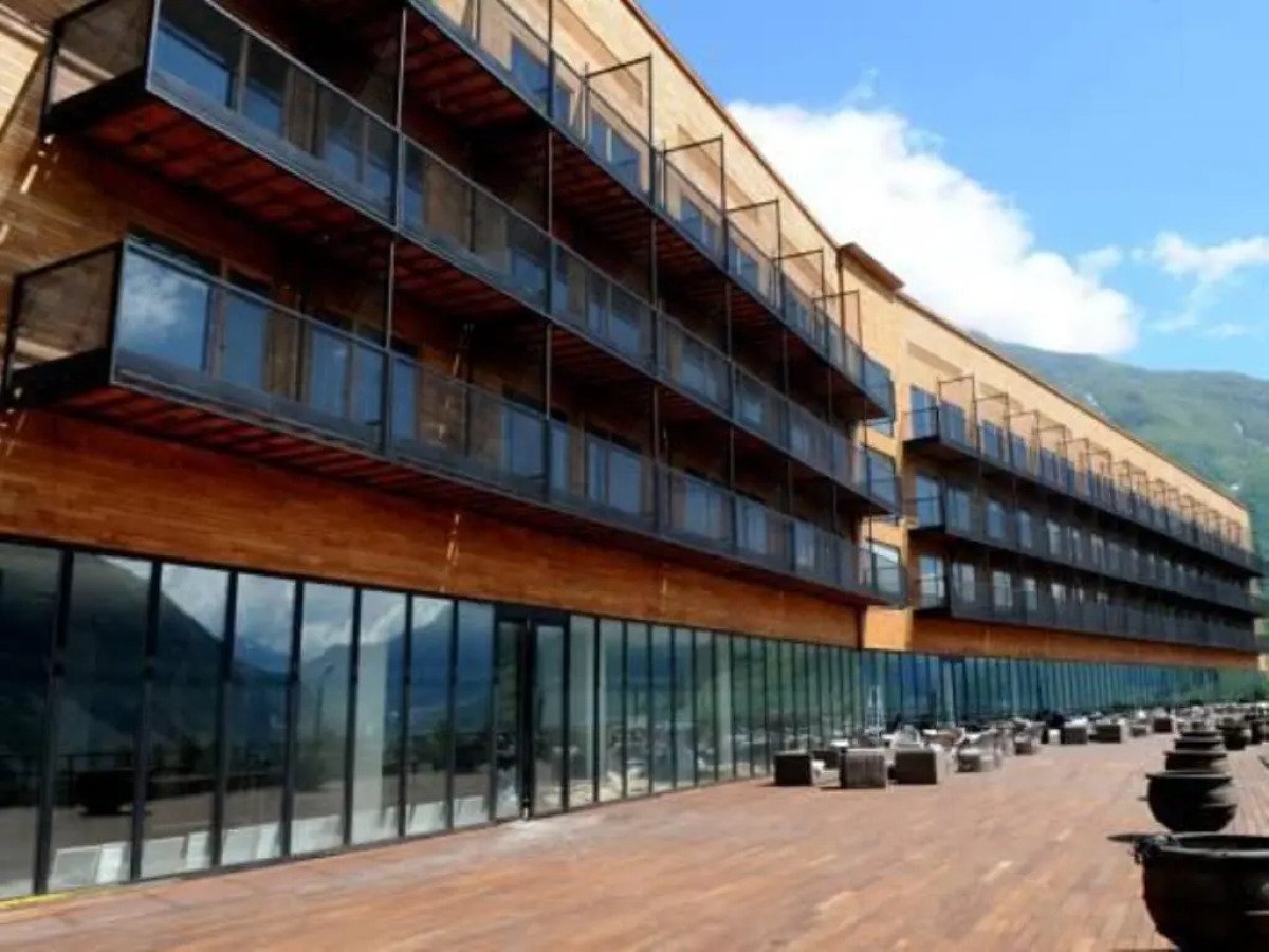 Výrazná moderní budova hotelu Rooms Hotel Kazbegi na pozadí Velkého Kavkazu, Stepancminda