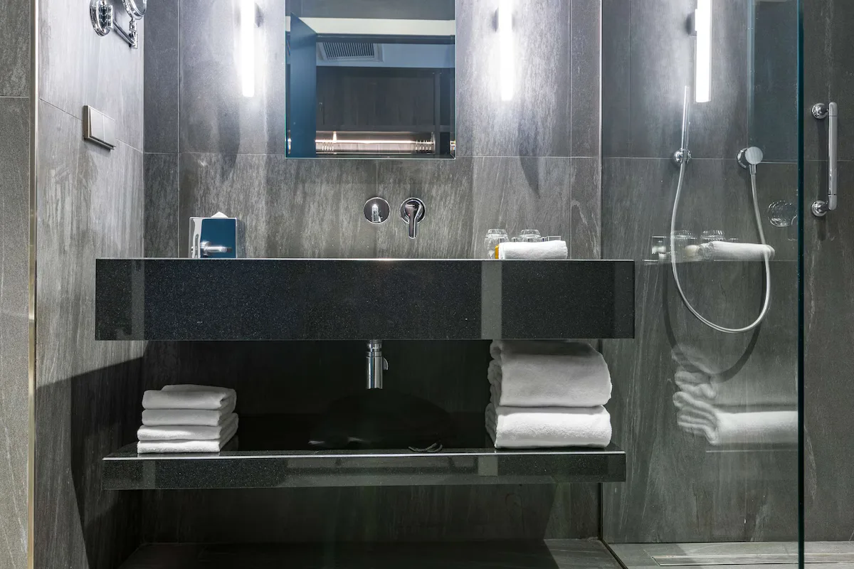 Gästebadezimmer im Tsinandali Estate, A Radisson Collection Hotel mit Steinoberflächen und Regendusche