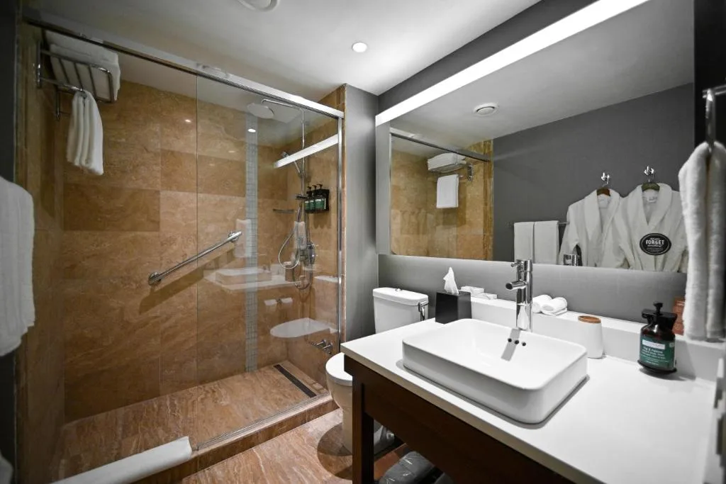 Salle de bains du Yerevan Place Hotel avec douche à l'italienne et peignoir