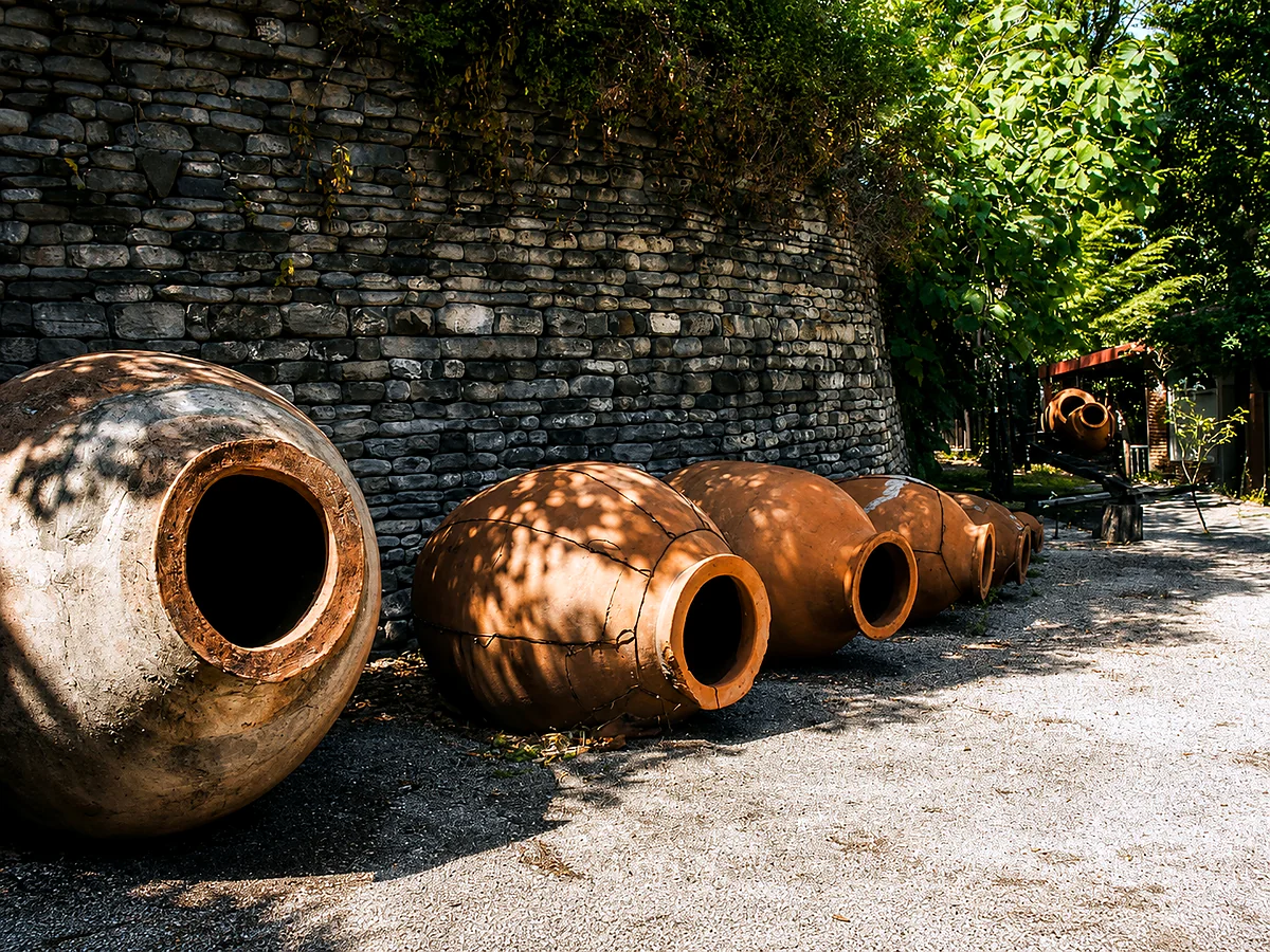 Grote kleien qvevri-wijnvaten tegen een stenen muur in Kakheti, Georgië