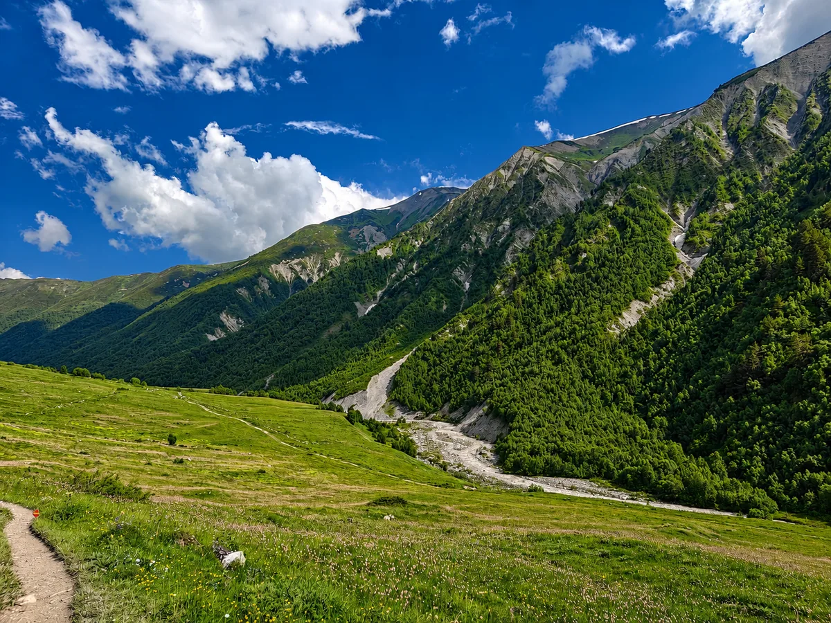 Zelené alpské údolí a stezka ve vysočině Svanetie u Ušguli, Gruzie