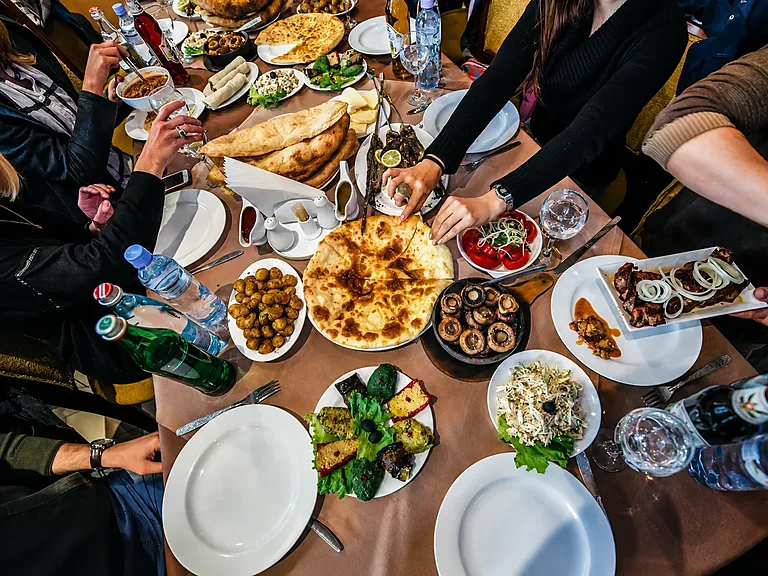 Traditionelle georgische Supra-Tafel mit Chatschapuri und gemeinsamen Gerichten, Georgien